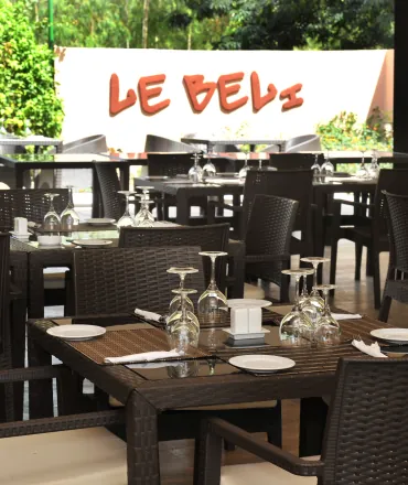 Le restaurant Le Béli, tables en bois sombre sous l'enseigne