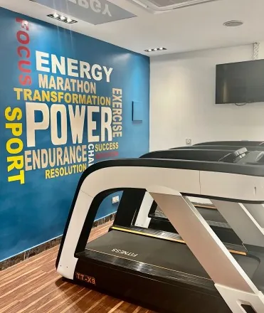 La salle de sport, tapis de course et mur bleu